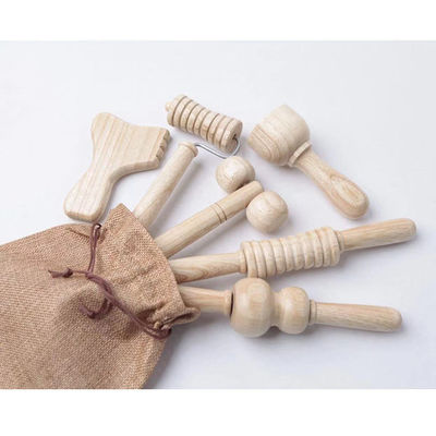 Bruine massager van massief hout met een massagestok met handvat.